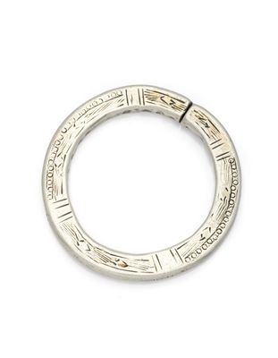 gros plan d'une bague en argent sur une surface blanche