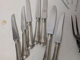 a lot of knives and a pair of scissors on the table