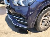 a close up of a blue mercedes suv parked in a parking lot