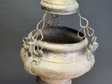 an old metal hanging planter with a bell on top of it