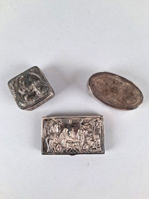 trois petits objets argentés posés sur une surface blanche