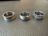 trois bagues en argent posées sur une surface en cuir
