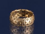 un gros plan d'une bague en or sur une surface bleue
