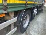 a green and yellow semi truck parked on the side of the road