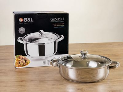 une casserole en acier inoxydable et une boîte posées sur une table