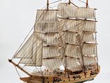 a wooden model of a sailboat on a stand