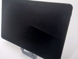 a black computer monitor on a stand on a white surface