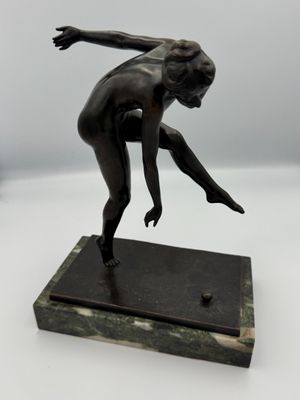 bronze statue of a female figure on a marble base
