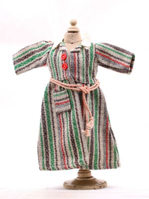 robe rayée posée sur un socle de mannequin orné d'un bouton rouge