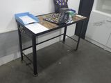 une petite table sur laquelle se trouvent un clavier et un téléphone portable