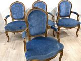 Quatre chaises bleues sont posées sur un parquet dans une pièce