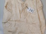 a white shirt with a tag on it on a table