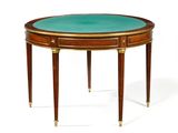 une table ovale avec un plateau en verre vert et des pieds dorés