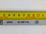 a ruler that is measuring the width of a piece of metal