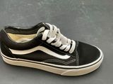 a pair of black and white shoes on a gray surface