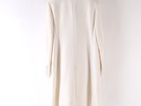 a white coat on a hanger against a white wall