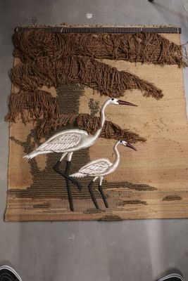 two birds that are standing on a rug on the floor