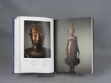 an open book with a picture of a buddha statue on it