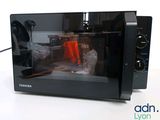 a black microwave oven sitting on a white table