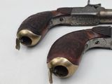 a pair of old revolvers sitting on top of a white surface