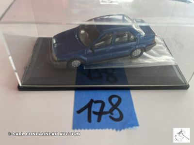 une petite voiture bleue dans une vitrine posée sur une table