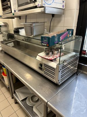 plan de travail en acier inoxydable dans une cuisine professionnelle équipée de fours à micro-ondes et d'autres appareils électroménagers