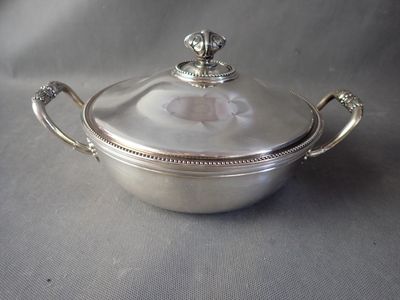 an antique silver plated casserole with a lid and handles