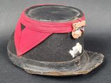 un chapeau noir orné d'un ruban rouge