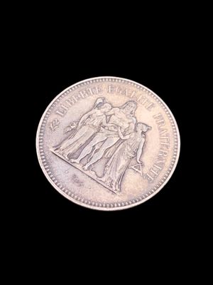 une vieille pièce d'argent sur laquelle figurent les portraits d'une femme et d'un homme