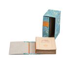 an open book sitting inside of a blue box on top of a white surface