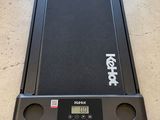 un tapis de course noir posé sur un parquet