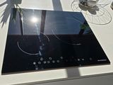 a glass stove top with a black burner on it