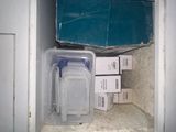 a plastic container sitting on top of a counter next to a stack of boxes