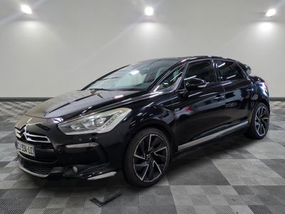 la voiture noire est garée sur un sol en damier dans le garage