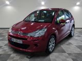 the red citrole is parked on a checkered floor in a garage
