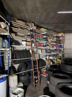un garage où s'entassent de nombreux pneus sur les étagères