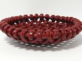 a close up of a red bowl on a white surface