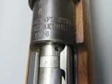 a close up of a rifle with a wooden frame and a metal handle