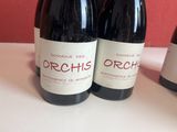 three bottles of red wine sitting on a table