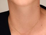 a woman wearing a black shirt and a gold necklace