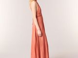 the woman is wearing a dress and sandals standing in front of a white background