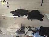 a white shelf with a bunch of black clothes on it