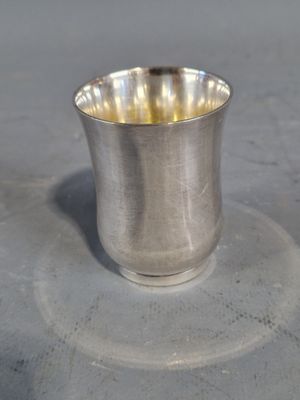 une tasse en argent posée sur une soucoupe