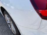 a close up of a white car with a red tail light