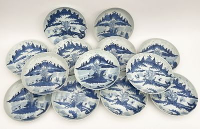 blue and white plates with designs of mountains and trees on them