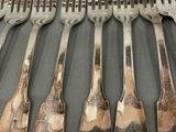 a lot of forks and spoons that are on a table