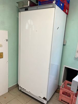 un réfrigérateur blanc dans un coin d'une pièce aux murs bleus