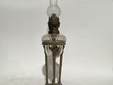 an old fashioned lamp with a glass shade on top of it