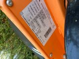 a close up of an orange street sign with a sticker on it
