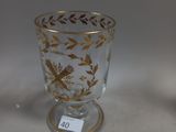 a glass cup with a gold leaf design on it